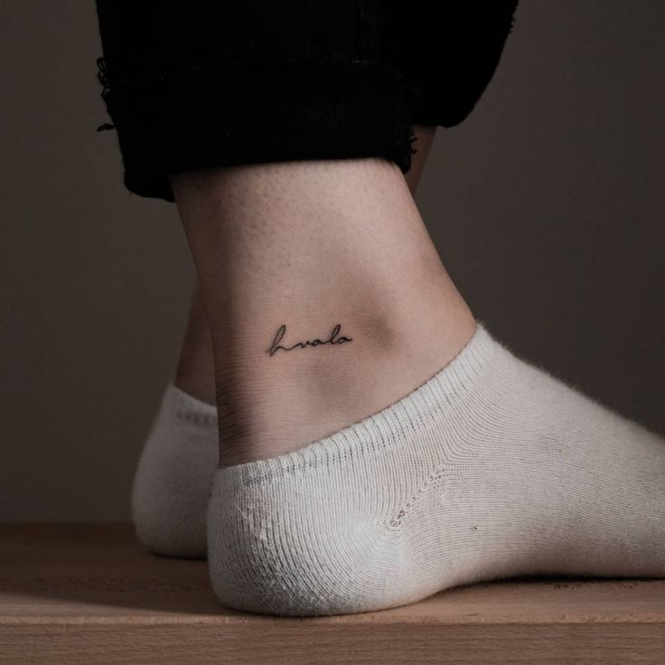 a woman's foot with a small tattoo that reads, love is in the air