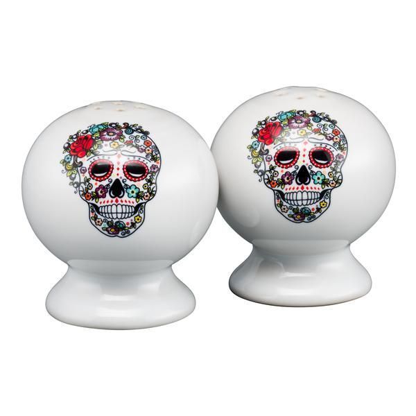 two white ceramic sugar skulls with colorful flowers on their heads, each decorated with a skull's head