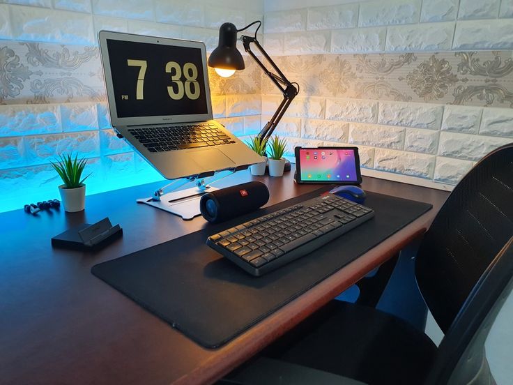 a laptop computer sitting on top of a wooden desk next to a keyboard and mouse