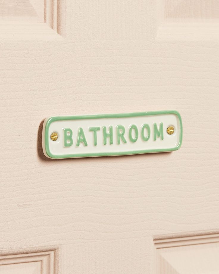 a bathroom sign on the front door of a house