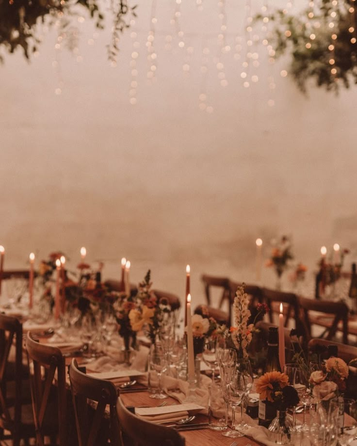 the table is set with candles, flowers and place settings for dinner guests to enjoy