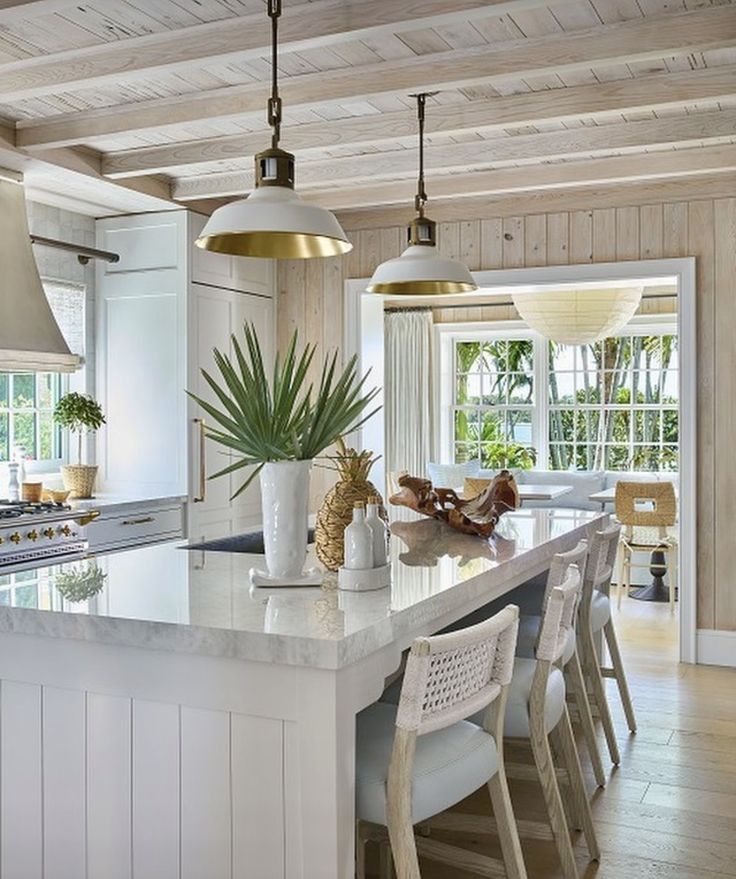 a kitchen with an island and two pendant lights hanging over it's counter top