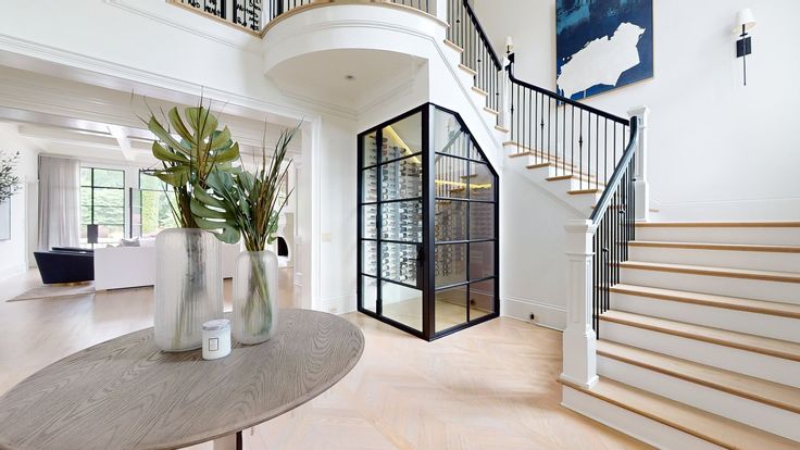 a large foyer with stairs leading up to the second floor and a plant in a vase