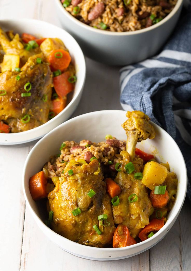 two white bowls filled with food on top of a table