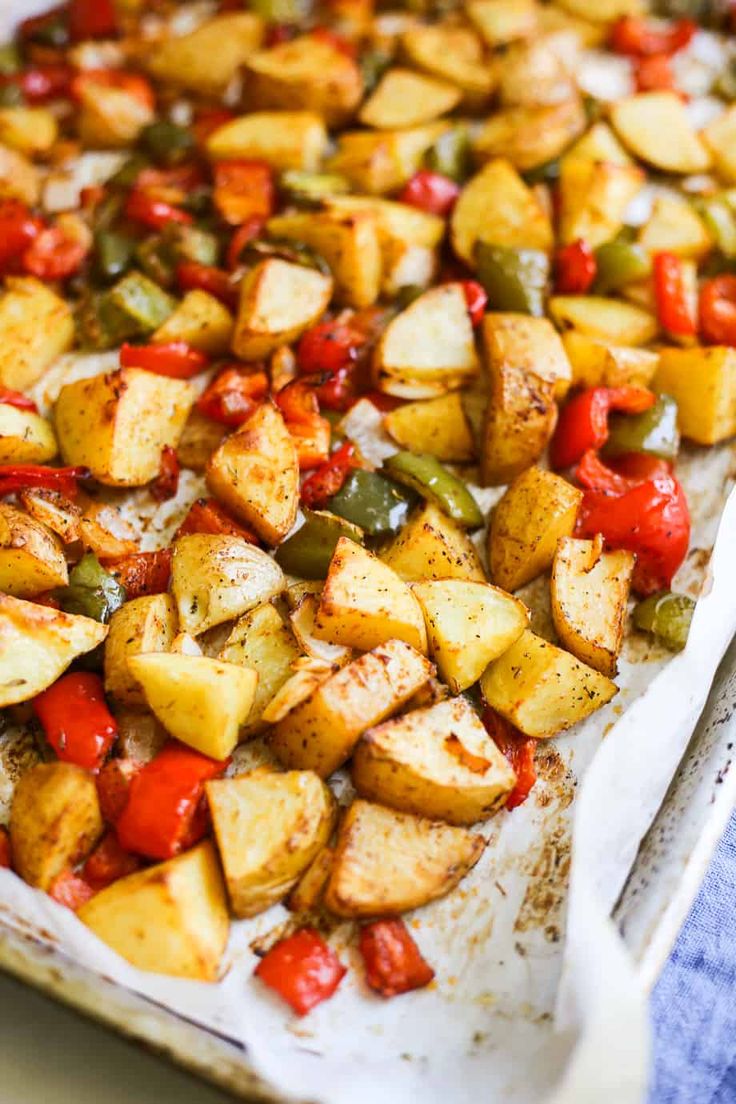 potatoes and peppers on a baking sheet ready to be cooked in the oven for dinner