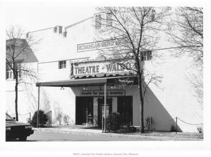 an old black and white photo of the theatre walk in front of a building with trees