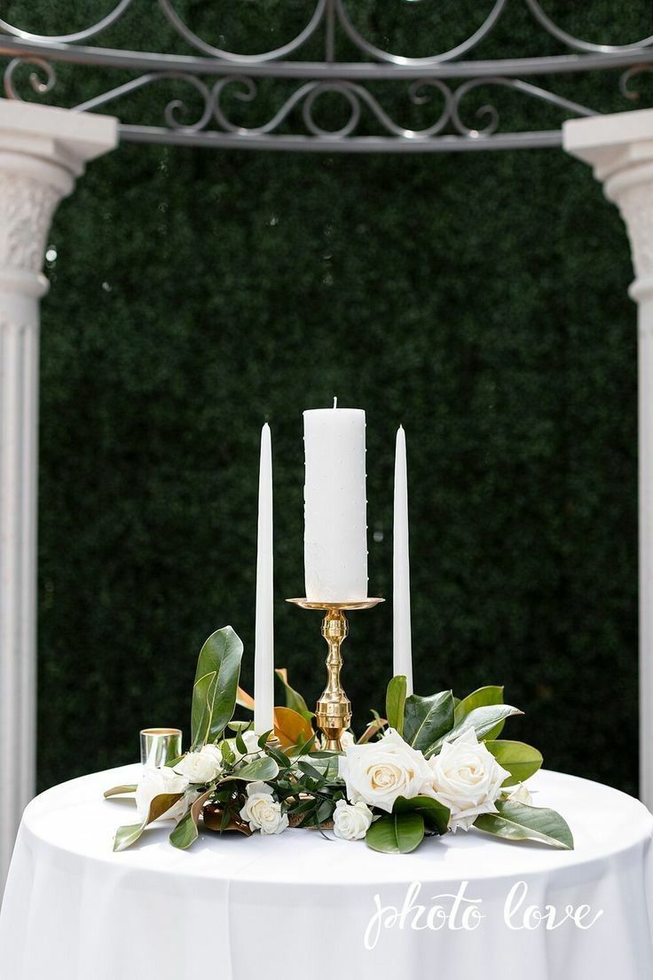 a white table with candles and flowers on it