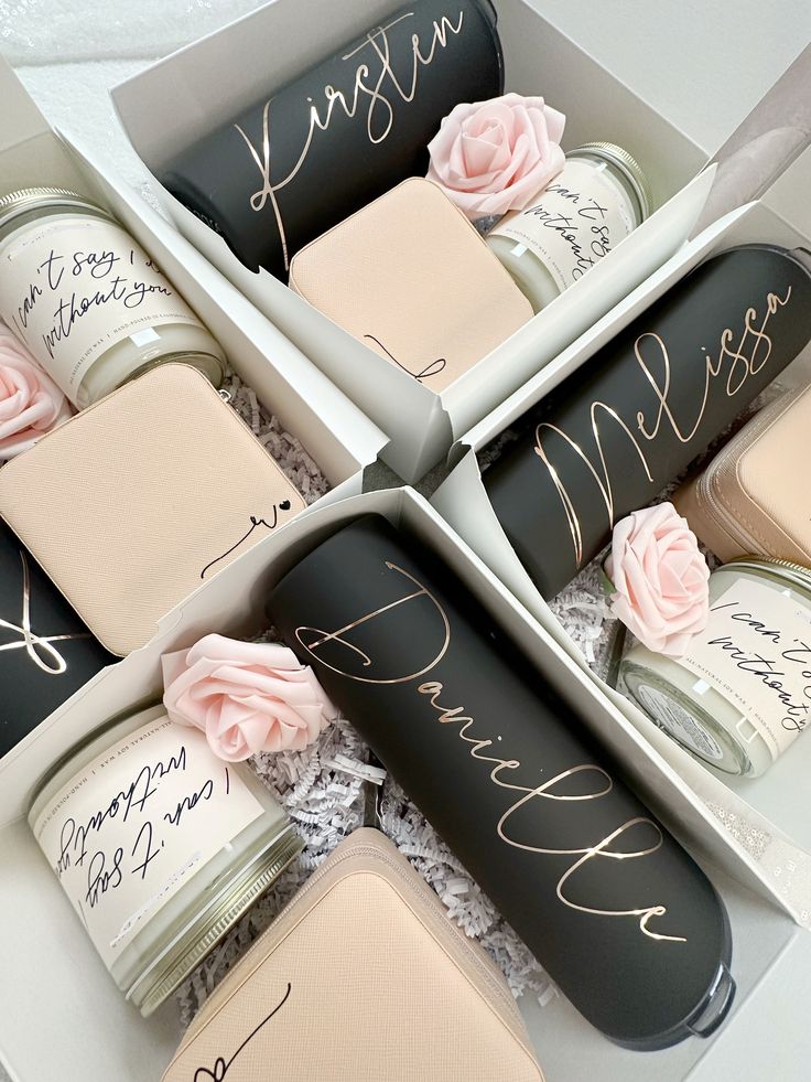 six personalized jars in a box with flowers and writing on the lids for wedding favors