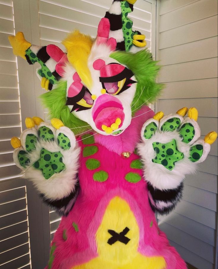 a colorful animal costume with green, yellow and pink paint on it's face