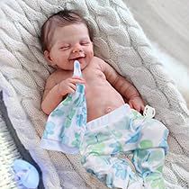 a baby wrapped in a blanket chewing on a toothbrush