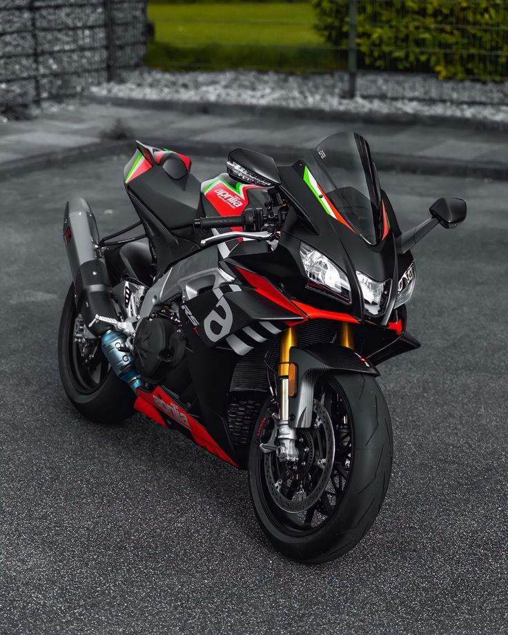 a red and black motorcycle parked in a parking lot