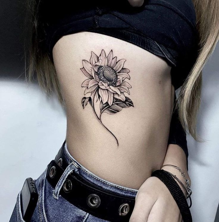 a woman with a sunflower tattoo on her stomach