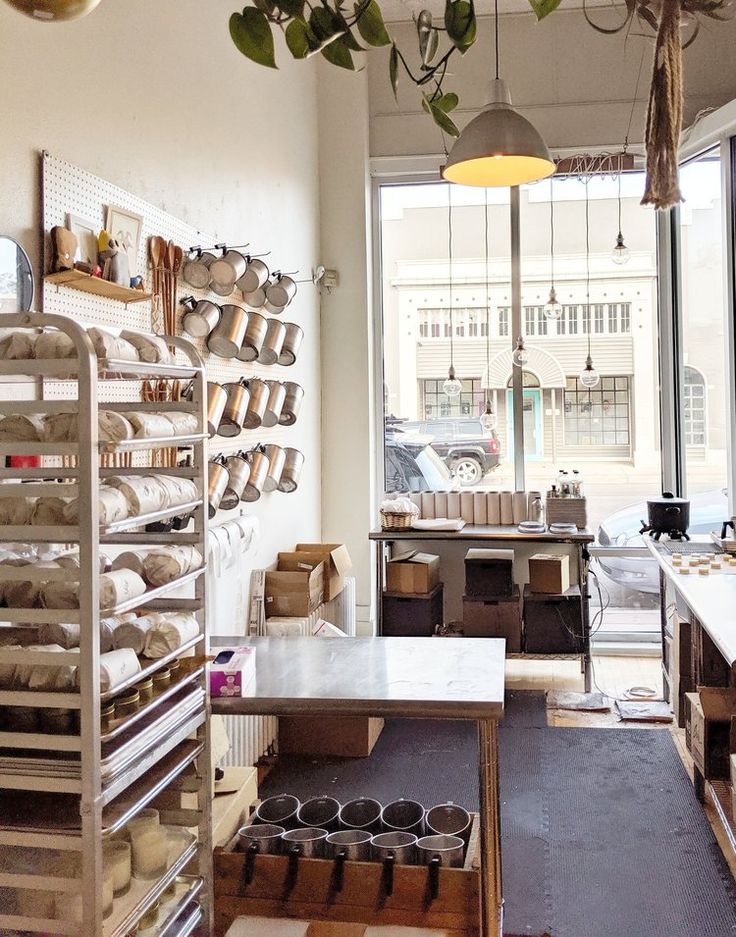 a room filled with lots of pots and pans on shelves next to a window