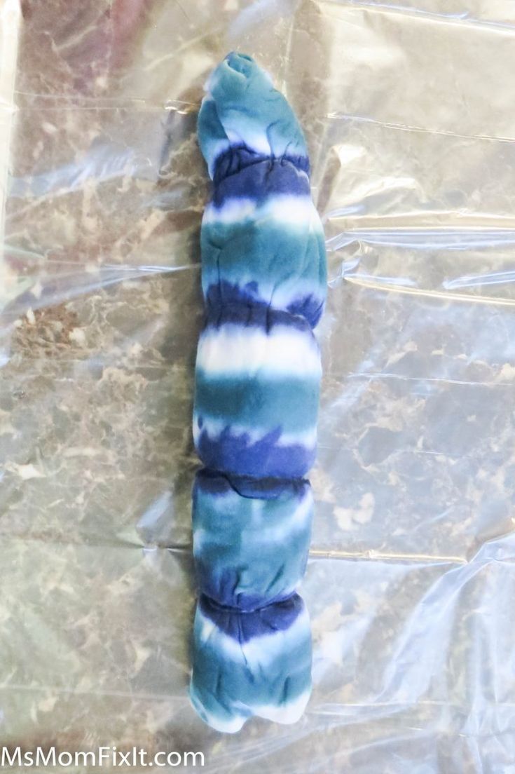 a blue and white tie - dyed tube sitting on top of a piece of plastic