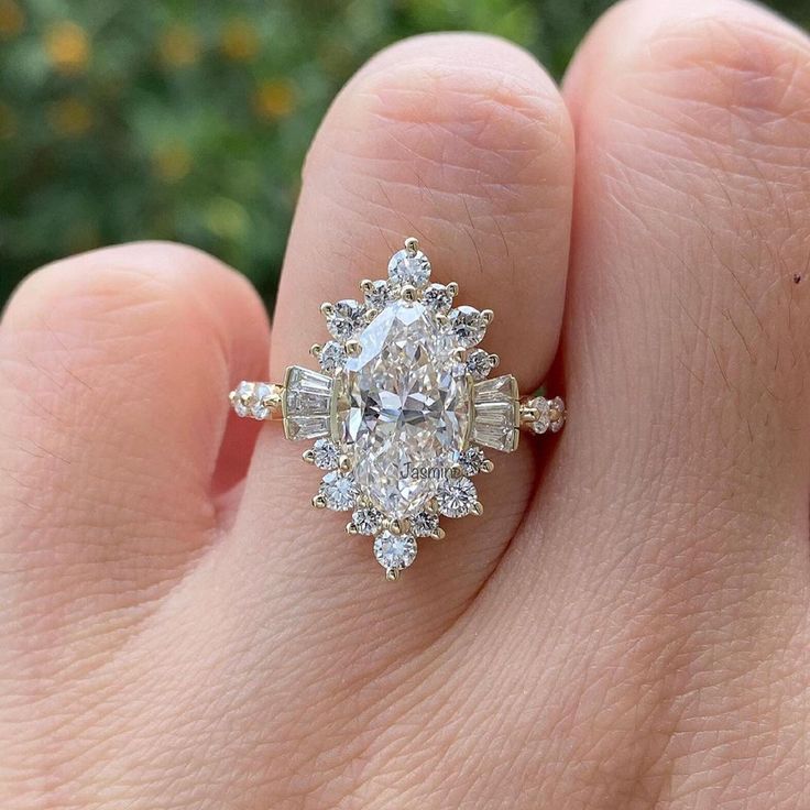 a woman's hand with a diamond ring on top of her finger and an engagement band