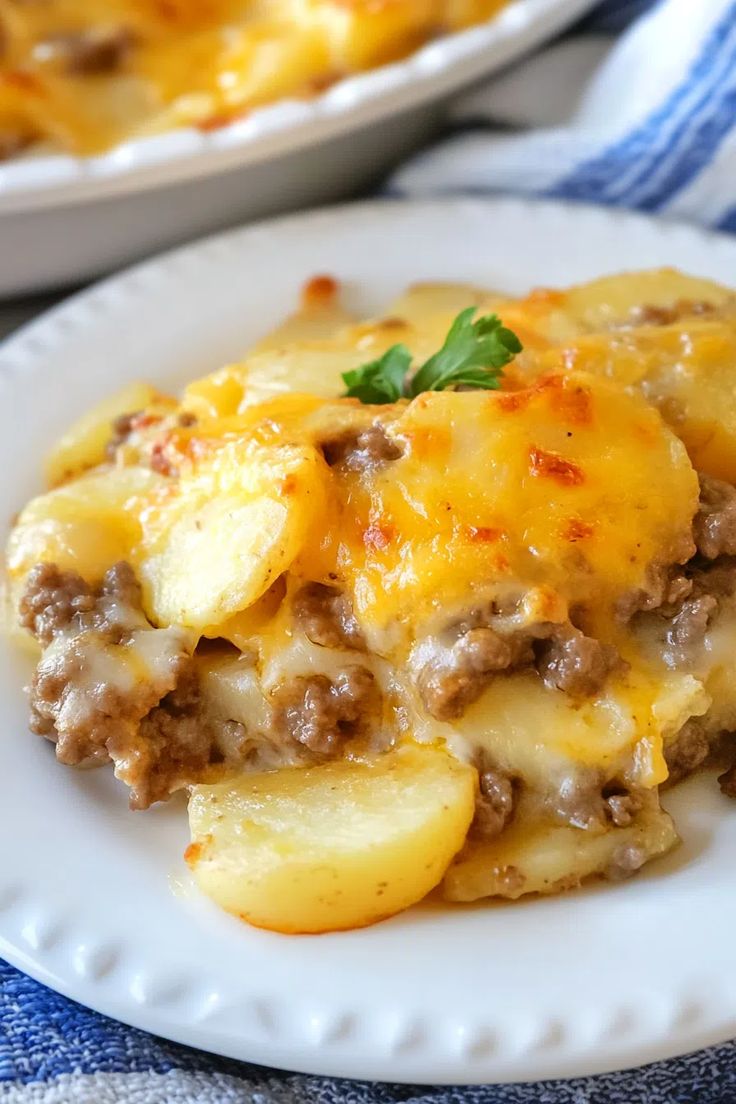 a white plate topped with cheesy potatoes covered in ground beef and gravy