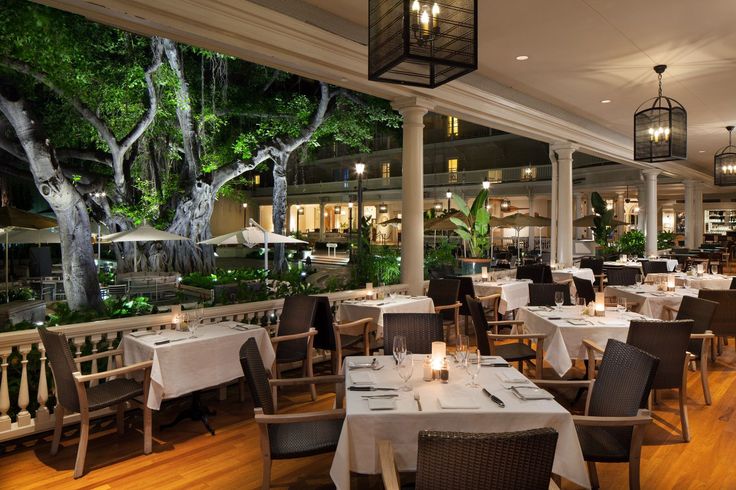 an empty restaurant with tables and chairs in front of the window, lit by lanterns