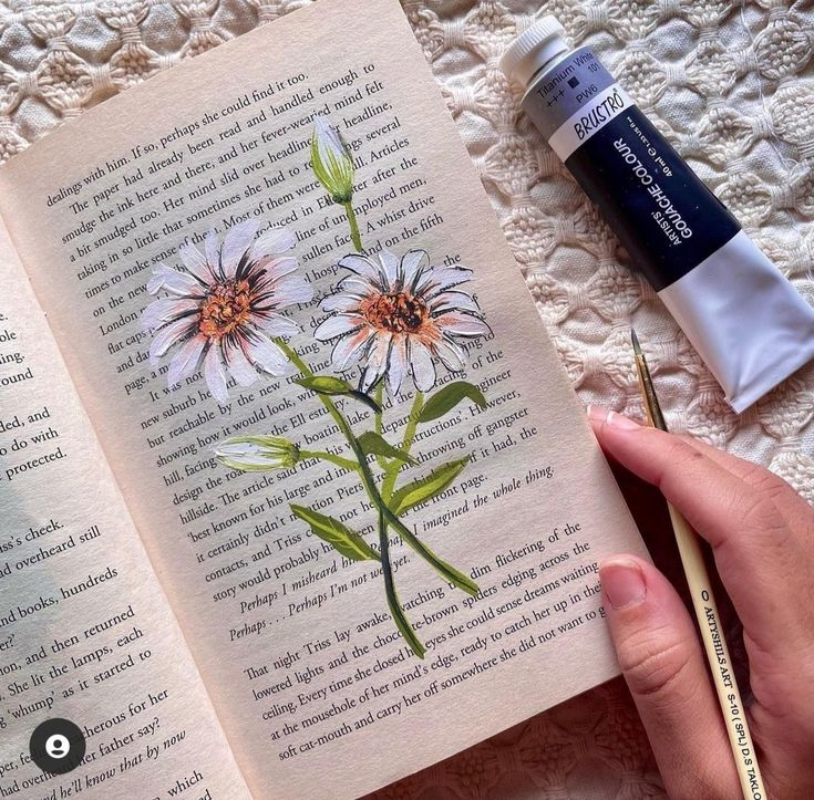 an open book with some flowers on it