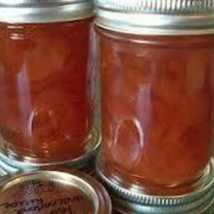 three jars filled with jam sitting on top of a counter