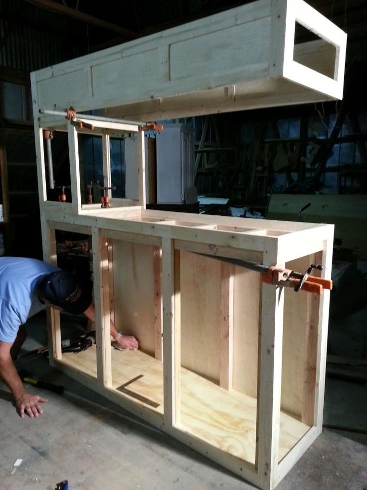 a man working on cabinets in a garage