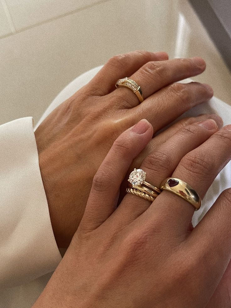 two hands holding each other while wearing wedding rings