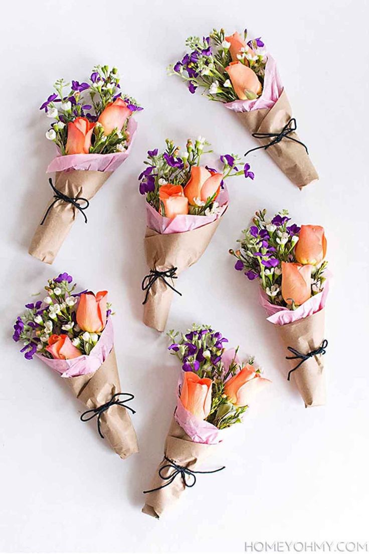 flowers wrapped in brown paper are arranged on the table