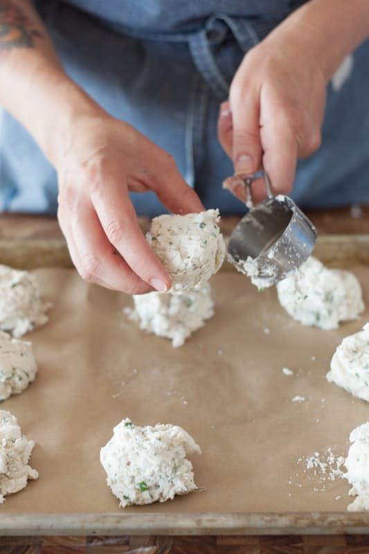 a person scooping something out of a cookie sheet on top of a baking sheet