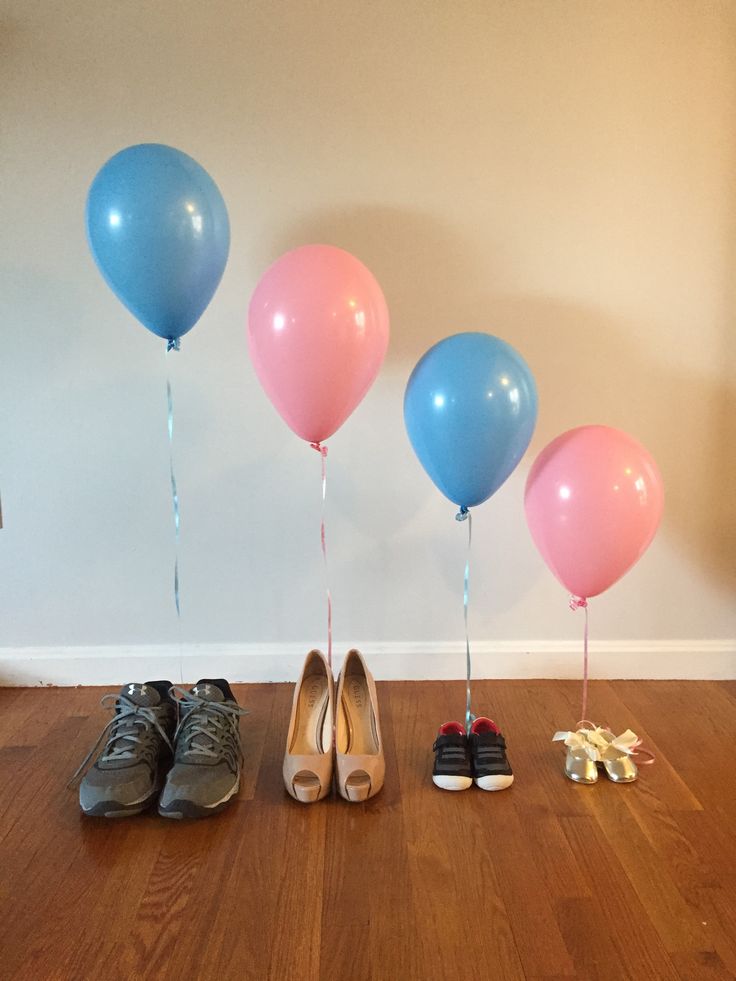 several pairs of shoes are lined up in front of three balloons and one pair is tied to the floor