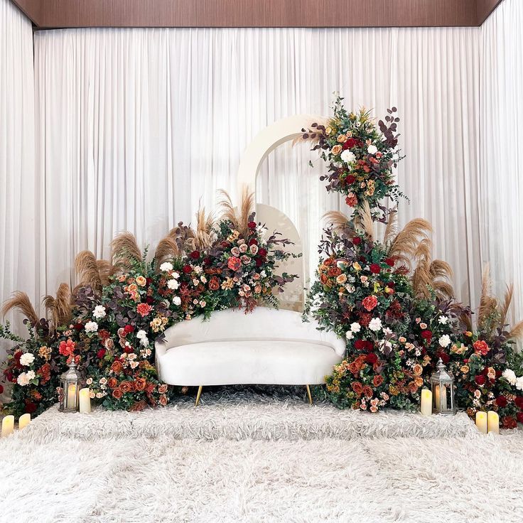 a white couch surrounded by flowers and candles