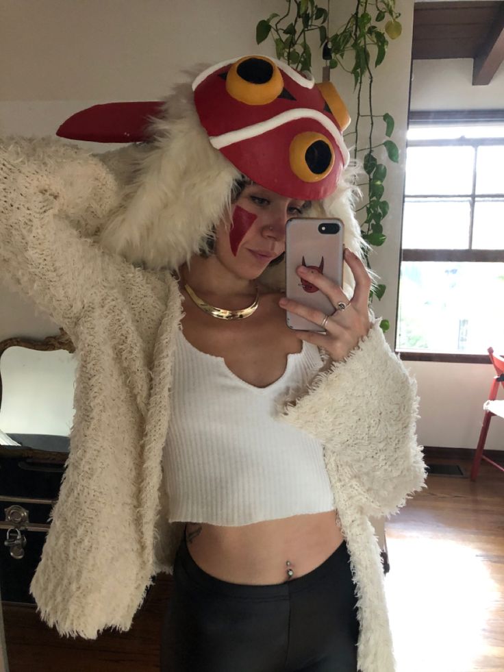 a woman taking a selfie with her cell phone wearing a red and white costume