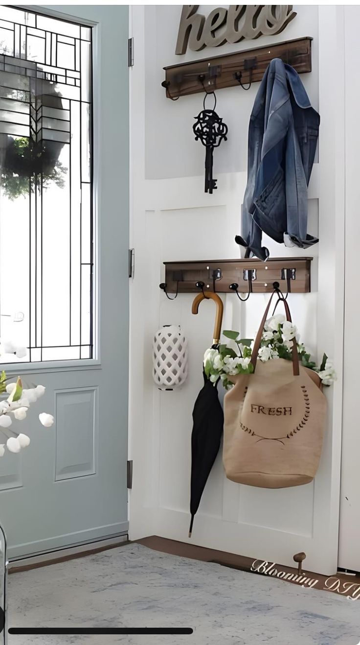 a white door with some hooks and umbrellas on it