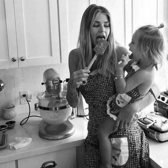 a mother and her daughter brushing their teeth in the kitchen