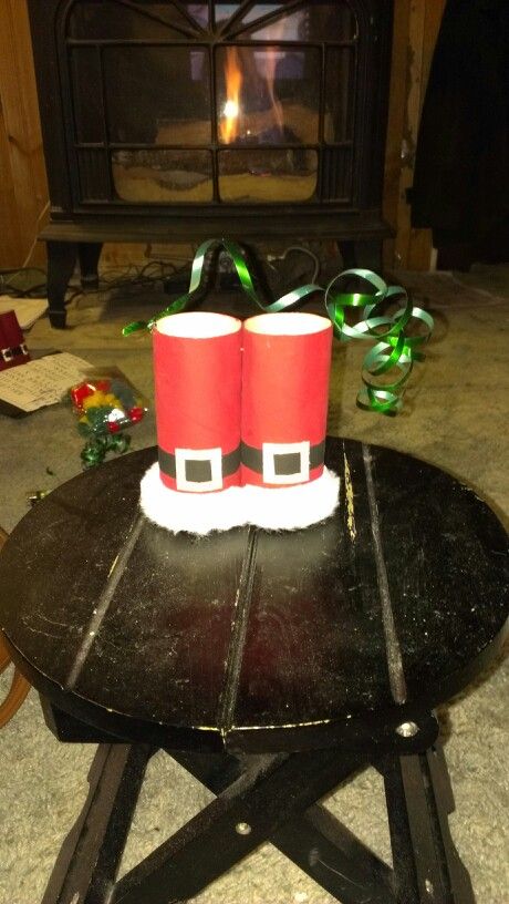 two red cups sitting on top of a wooden table in front of a fire place