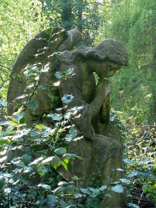 a stone statue in the middle of some trees