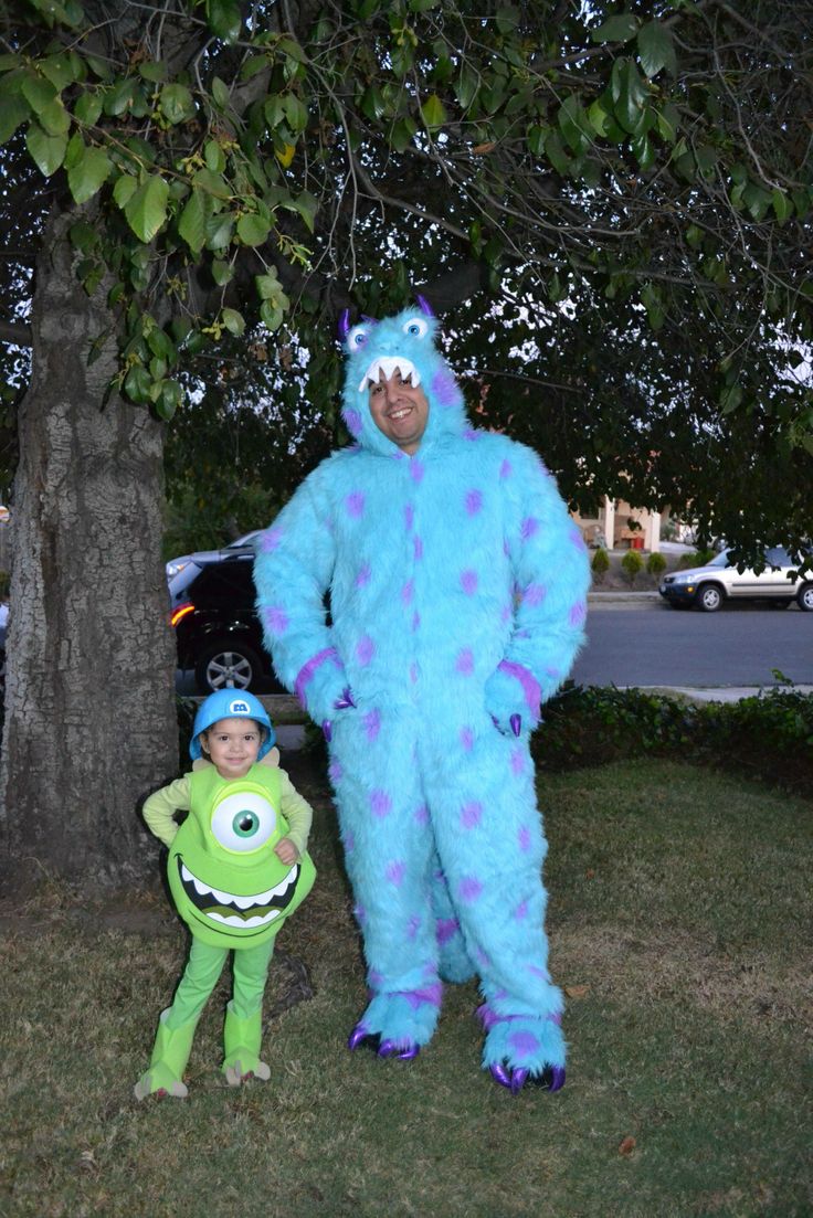 a man in a blue monster costume standing next to a little boy dressed as monsters