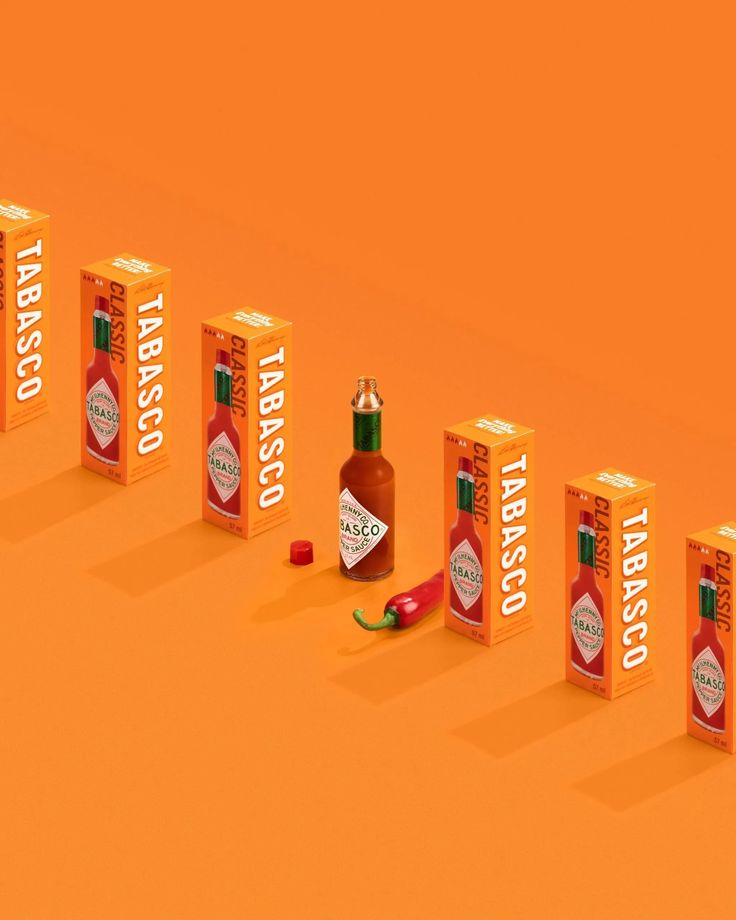 an orange background with three boxes containing hot sauce