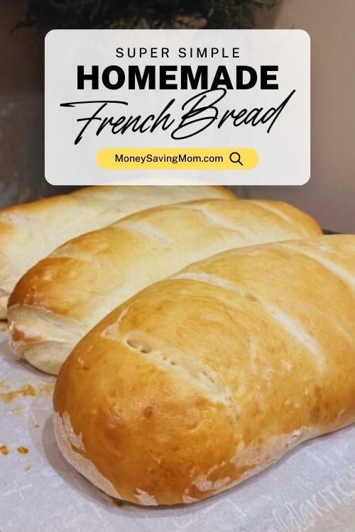 two loaves of bread sitting on top of a white table cloth next to a sign that says homemade french bread