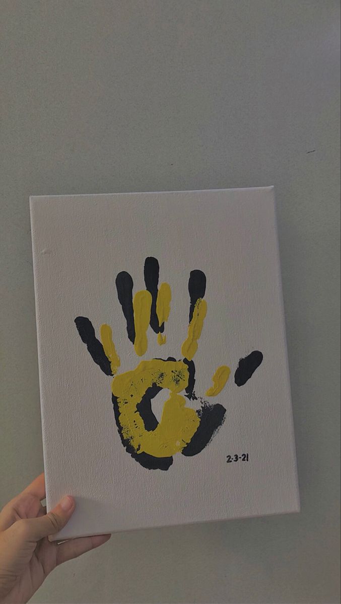 a person holding up a piece of paper with a hand print on it