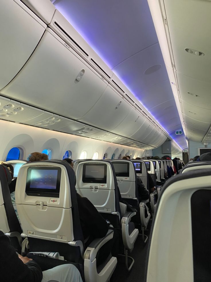 the inside of an airplane with people sitting on seats