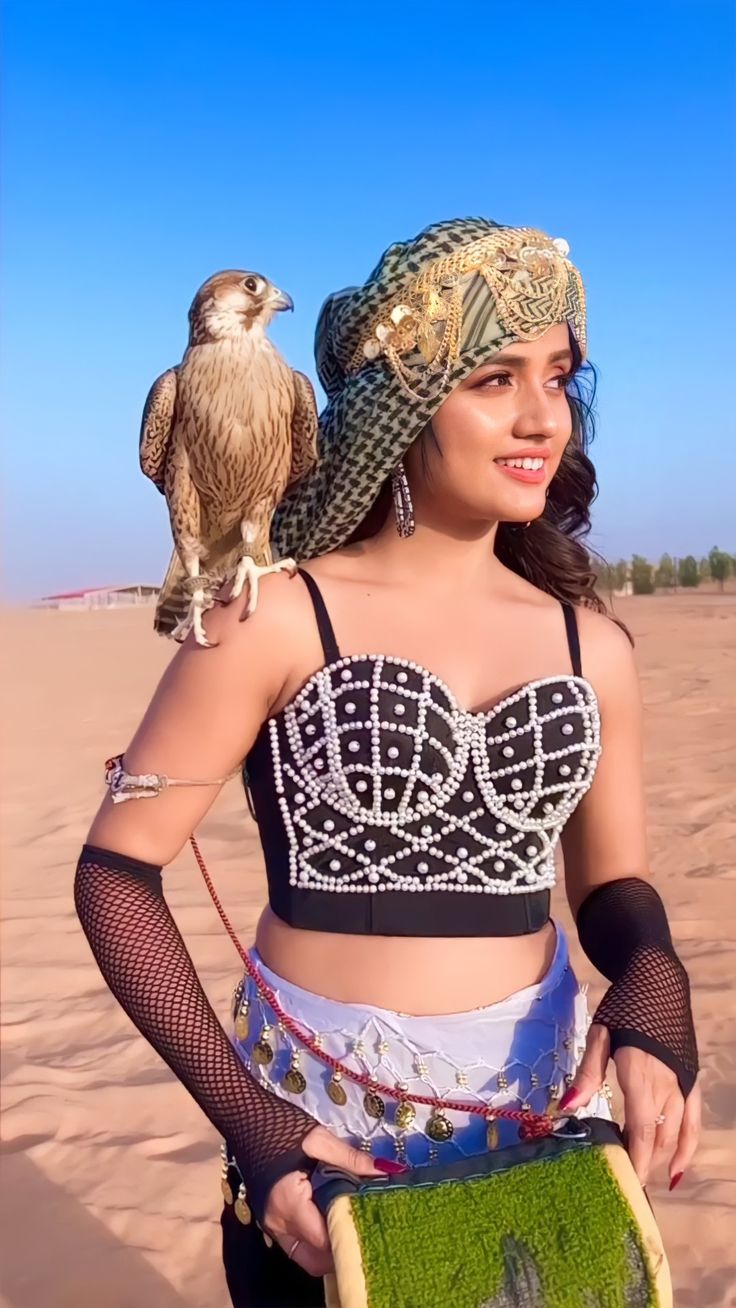 a woman with an owl on her shoulder holding a piece of food in her hand