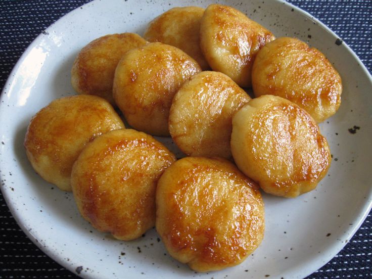 a white plate topped with doughnuts on top of a blue tablecloth covered table