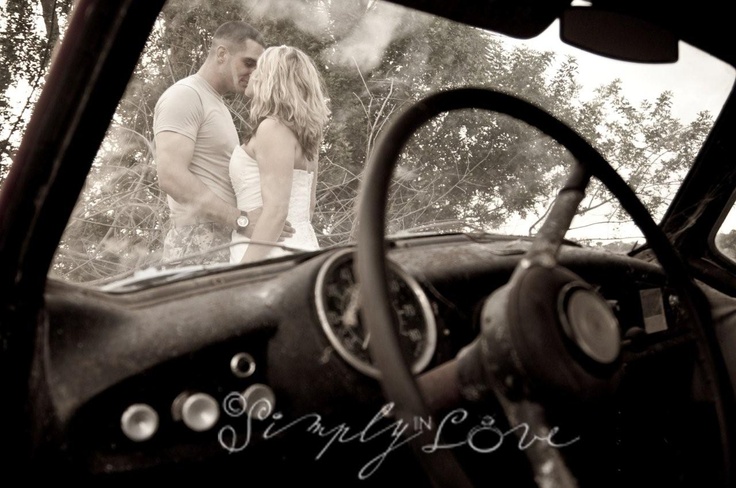 a man and woman kissing in an old car