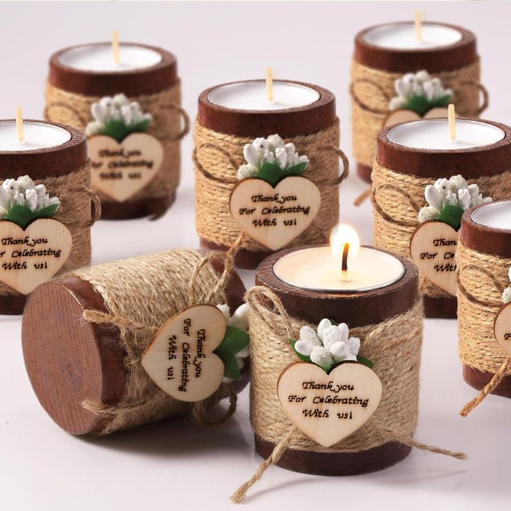 many small candles are wrapped in twine and have hearts on them with words written on them