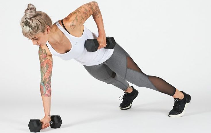 a woman doing push ups with dumbbells