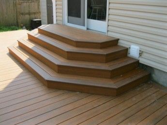 a wooden deck with steps leading up to the door