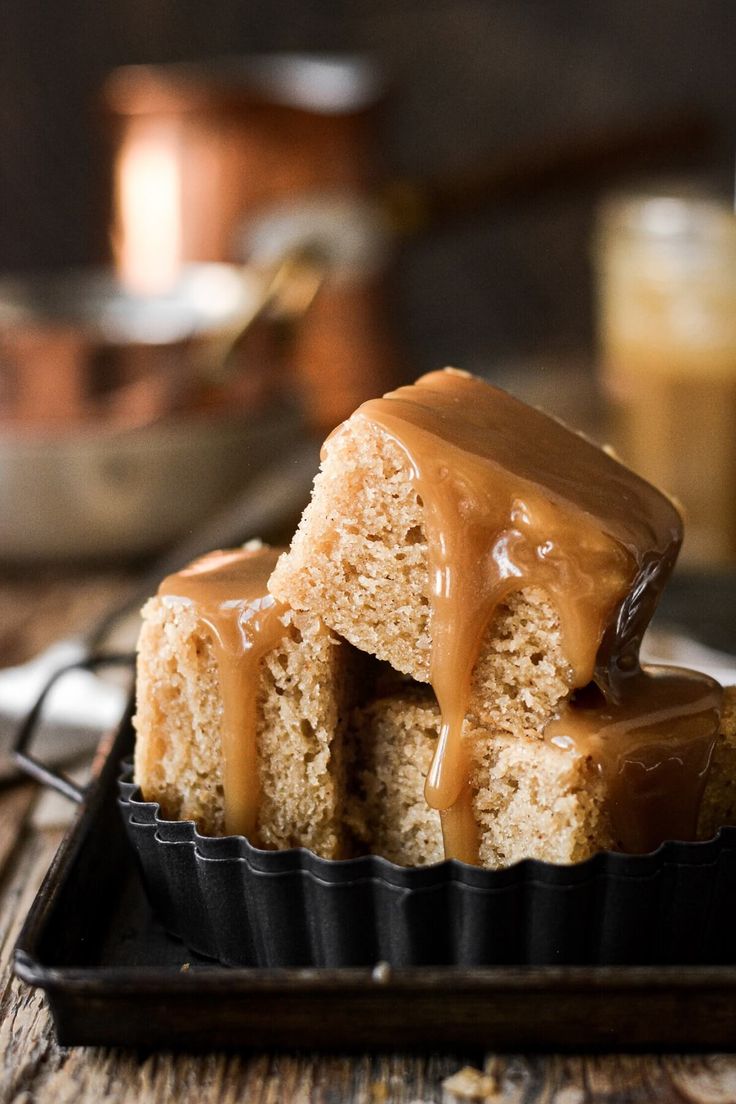 two pieces of cake with caramel drizzle on top, sitting in a cupcake tin