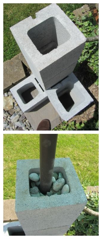 an outdoor fountain made out of cement blocks and rocks, sitting in the grass next to a