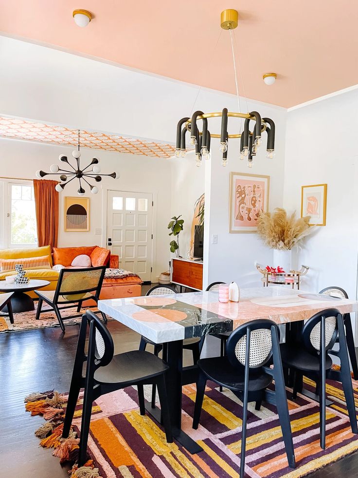 a dining room table with chairs and a rug on the floor