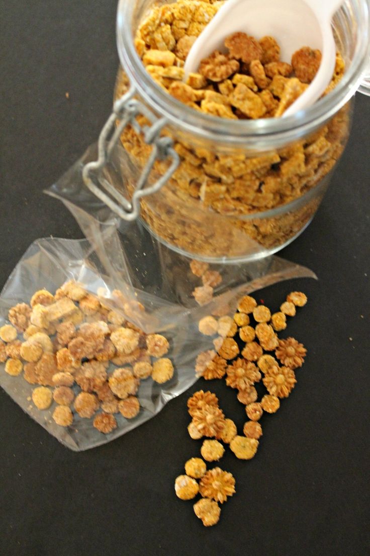 a jar filled with granola sitting on top of a table next to a bag of granola