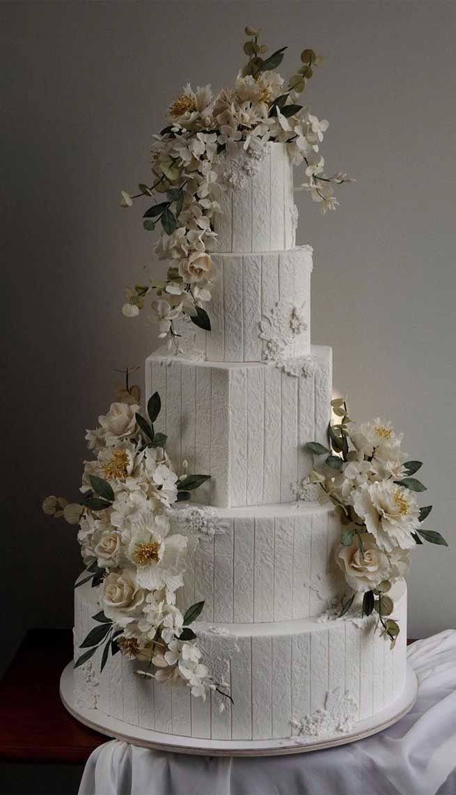 a white wedding cake with flowers on top